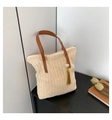 Détail du sac cabas en paille avec anses en cuir marron et pompon jaune sur la table - Blanc Cassé