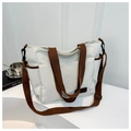 Détail du sac cabas en toile avec lanières marron, multiples poches et texture résistante - Blanc