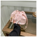 Detail der rosa Kordelzug-Beuteltasche mit weißen Schleifen und goldener Kette - Rosa