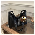 Détail d'un sac cabas en cuir noir souple avec pendentif en peluche sur une table - Noir