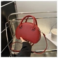 Detailed view of red crescent handbag with round handle and silver metal zipper - Red