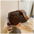 Detailed view of brown quilted crossbody bag with stylish geometric pattern woven strap - Brown