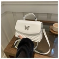 Close-up of a white leather crossbody bag with silver butterfly buckle and V-quilt pattern - White