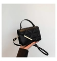 Detail of black quilted shoulder bag featuring modern geometric patterns and gold metal bar - Black