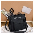 Gros plan du sac cabas en toile noire avec broderie de lettres et poches latérales à cordon - Noir