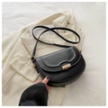 Detail of black PU leather saddle bag with golden cylindrical metal buckle closure - Black