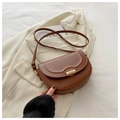 Close-up of brown saddle bag showing U-shaped stitching and golden metal hardware detail - Brown