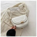 Detailed view of white leather saddle bag with gold metal ring clasp on a cream blazer - White