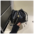Détail du sac seau noir à cordon avec chaîne dorée et breloque boule en métal évidée - Noir