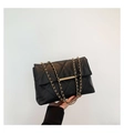 Détail d'un sac bandoulière noir matelassé avec chaîne dorée et fermoir métallique - Noir