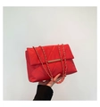 Détail d'un sac à bandoulière matelassé rouge vif avec chaîne dorée et fermoir en métal - Rouge