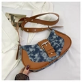 Detail of blue denim and brown leather stitching on a retro saddle bag with silver buckle - Deep Sky Blue