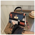 Close-up of vintage plaid handbag with golden twist lock and structured leather handle - Colorful