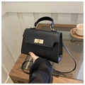 Close-up of black handbag with contrast matte leather, glitter finish and gold lock - Black