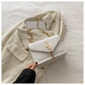 Detail of white envelope bag featuring a gold SS logo and elegant chain tassels - White