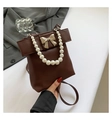 Dark brown pearl handle crossbody bag with a golden bow clasp and smooth leather finish - Brown