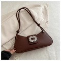 Detail of dark brown leather underarm bag featuring a large sparkling rhinestone buckle - Brown