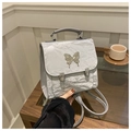 Nahaufnahme der silbernen Rucksack-Textur mit großen metallischen Schmetterlingsdekor - Silber