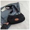Top view of a black canvas crossbody bag with adjustable strap on a minimalist background - Black