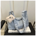 Gros plan du sac cabas en daim bleu clair avec large bandoulière et charmant pendentif - Bleu (Avec Pendentif)