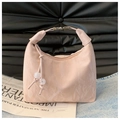 Detail der rosa Handtasche mit Marmortextur, Metallverschluss und kugelförmigen Anhängern - Rosa