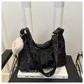 Détail du sac fourre-tout noir texturé avec breloque cœur en peluche blanche sur un livre - Noir (avec pendentif)