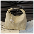 Detail der beigen Handtasche mit Lederstruktur, Tunnelzug-Perlen und Metallschnallendesign - Khaki