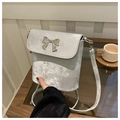 Close-up of a silver bucket bag featuring a metallic bow detail and shimmering texture - Silver