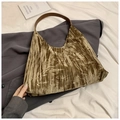 Dettaglio di una borsa tote marrone in velluto a coste con motivi a foglia su una giacca - Marrone