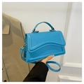 Sky blue stylish shoulder bag with wave stitch flap and gold hardware held by a person - Blue