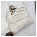 Detail der weißen Textur-Tasche mit Hohlgriff und Goldschnalle auf minimalistischem Grund - Gebrochenes Weiß