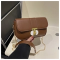 Dettaglio di una borsa a tracolla marrone con catena dorata e elegante chiusura a T in metallo - Marrone