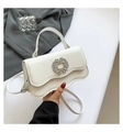 Ivory crossbody bag with rhinestone buckle and scalloped flap shown in hand - White