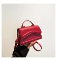 Modieuze rode lederen crossbody tas met golvende stiksels en gouden metalen gesp - Bordeauxrood