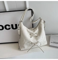 Detail der cremefarbenen Falten-Schultertasche mit Schleifendekor und Metallkette - Gebrochenes Weiß