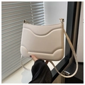 Detalle del bolso bandolera de cuero crema con elegante diseño de costuras onduladas - Blanco