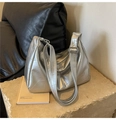 Borsa tote argento con cuciture geometriche su una superficie in pietra - Argento