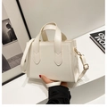 White minimalist leather tote bag with gold hardware and adjustable crossbody strap - White