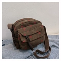 Detail of dark brown corduroy crossbody bag with red strawberry pattern on denim background - Brown