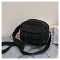 Close-up of black corduroy shoulder bag featuring red strawberry prints and buckle pocket - Black