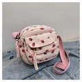Detail of pink corduroy crossbody bag featuring red strawberry patterns and a front pocket - Pink
