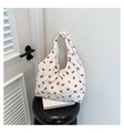 Detailed texture of white corduroy tote bag with red strawberry prints on a side table - Strawberry Style