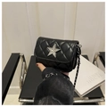 Detail of black quilted mini square bag featuring a crystal star and silver chain strap - Black