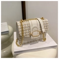 Close-up of quilted tweed flap bag featuring elegant gold hardware and chain strap - White