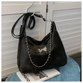 Minimalist black velvet shoulder bag with a silver butterfly buckle and metal chain detail - Black