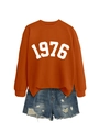 Close-up of 1976 printed orange sweatshirt paired with distressed denim shorts - Burnt Orange (White Font)