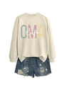 Détail à plat d'un sweat beige OMA life assorti à un short en jean bleu délavé à trous - Sable