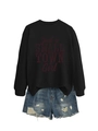 Detail of black sweatshirt with red slogan print and distressed blue denim shorts - Black