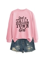 Close-up of pink sweatshirt with Just a Small Town Girl text and ripped denim shorts - Pink