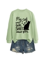 Flat lay of light green sweatshirt with cat slogan print and distressed denim shorts - Olive Green (Black Font)